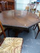 AN OAK VICTORIAN GOTHIC REVIVAL OCTAGONAL TABLE, THE PLANK TOP WITH LEAF CARVED EDGE, THE COLUMN