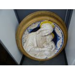 A FRAMED DELLA ROBBIA TYPE POTTERY PLAQUE OF THE MADONNA AND CHILD THEIR YELLOW HALOES CONTRASTING