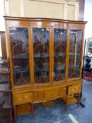 AN EDWARDIAN SATINWOOD DISPLAY CABINET WITH CENTRAL BOW FRONT DOORS ENCLOSING GLASS SHELVES OVER