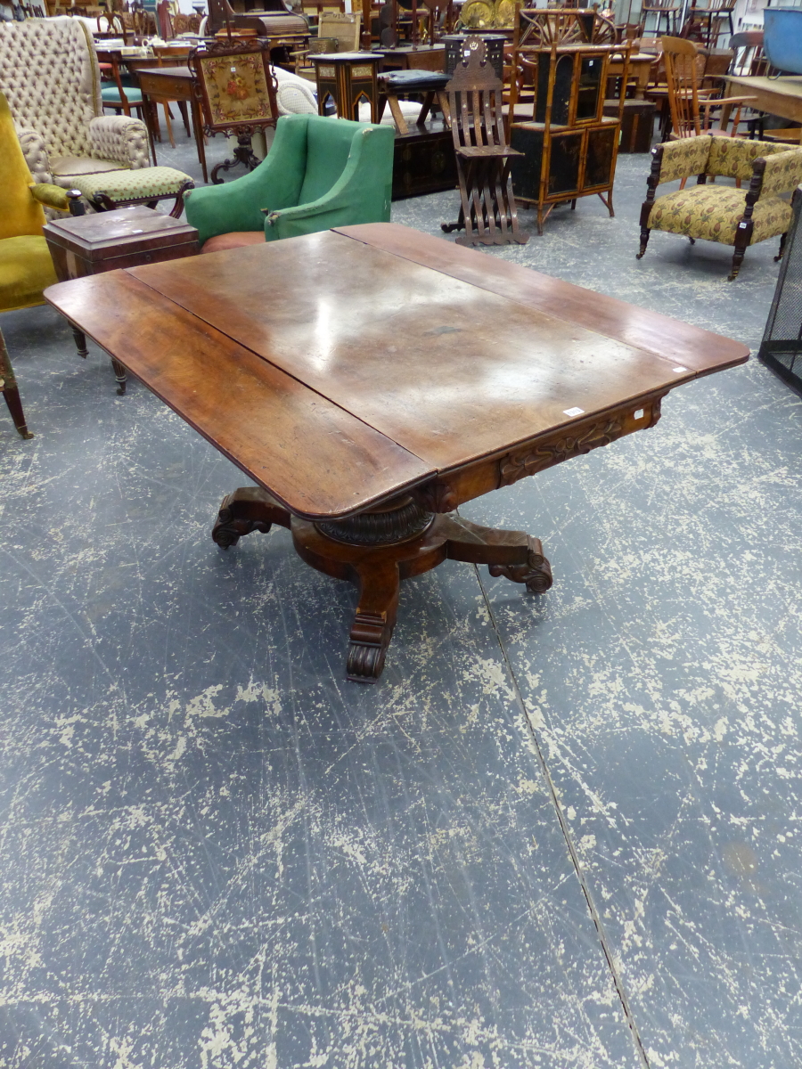 AN EARLY VICTORIAN CARVED MAHOGANY DROP LEAF LIBRARY TABLE WITH TAPERED PEDESTAL AND SCROLL FEET.