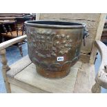 A BRASS COAL BUCKET WITH LION MASK AND RING HANDLES, THE ARMORIAL ENGRAVED SIDES ROUNDING DOWN TO