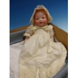 AN ARMAND MARSEILLE 351 BISQUE HEADED DOLL WITH SLEEPY EYES AND OPEN MOUTH DRESSED IN YELLOW CAP AND