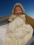 AN ARMAND MARSEILLE 351 BISQUE HEADED DOLL WITH SLEEPY EYES AND OPEN MOUTH DRESSED IN YELLOW CAP AND