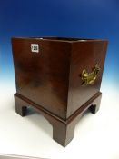 A MAHOGANY TEA KETTLE STAND WITH BRASS HANDLES TO THE SQUARE SIDES ABOVE BRACKET FEET, THE RIM