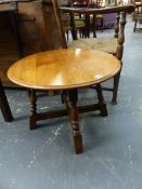 AN OAK CIRCULAR COFFEE TABLE, THE FOUR BALUSTER LEGS JOINED BY CRUCIFORM STRETCHER. Dia. 61 x H 44.