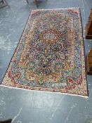 A PERSIAN KIRMAN RUG. 245 x 146cms.