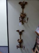 A PAIR OF GILTWOOD TWO LIGHT WALL BRACKETS TOPPED BY SPREAD EAGLES, A DRUM BELOW ONE AND A HELMET