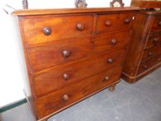 A VICTORIAN MAHOGANY CHEST OF TWO SHORT AND THREE LONG DRAWERS WITH BUN HANDLES STANDING ON TURNED