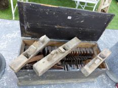 AN ANTIQUE PINE TOOL CHEST CONTAINING A GOOD SELECTION OF WOODEN MOULDING PLANES AND OTHER TOOLS. (