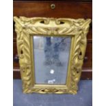 A RECTANGULAR MIRROR IN A BAROQUE STYLE GILT WOOD FRAME PIERCED AND CARVED WITH FOLIAGE. H 53 x 44.