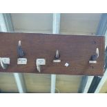 AN OAK MOUNTED RACK OF STAG ANTLER POINTS AS COAT HOOKS, EACH WITH LOCATION AND DATES TO INCLUDE BEN