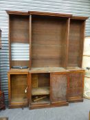 AN ANTIQUE OAK BREAKFRONT BOOKCASE WITH OPEN SHELVES ABOVE FOUR CUPBOARD DOORS ON PLINTH BASE. W.205