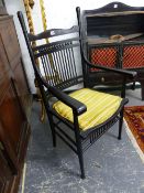 A WILLIAM MORRIS STYLE EBONISED ELBOW CHAIR, THE BACK WITH A BAND OF CYLINDRICAL RAILS BETWEEN