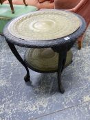 A COLONIAL CARVED EBONY AND BRASS TWO TIER ROUND TABLE, EACH TIER WITH ANIMAL CHASED BRASS INSETS.