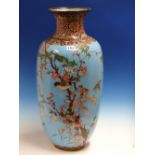 A JAPANESE CLOISONNE VASE WORKED WITH BIRDS AMONGST FLOWERS ON A SKY BLUE GROUND. H.60cms.