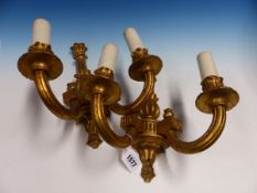 A PAIR OF GILT WOOD TWO BRANCH WALL LIGHTS, THE FLUTED NOZZLES AND ARMS SCROLLING TO THE BASES OF