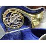A CASED ANBORO BRASS HORN WITH FOUR SILVERED STOPS.