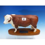 A BESWICK POLLED HEREFORD BULL STANDING ON A WOODEN BASE. W 30cms.