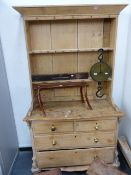AN ANTIQUE PINE DRESSER WITH PLATE RACK OVER CHEST OF TWO SHORT AND TWO LONG DRAWERS ON TURNED FEET.