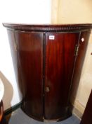 A GEORGIAN MAHOGANY TWO DOOR BOW FRONT CORNER CABINET. W.68 x H.100cms.