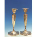 A PAIR OF HALLMARKED SILVER WEIGHTED HEXAGONAL TALL TABLE CANDLESTICKS. APPROX HEIGHT 25cms.