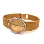 A LADIES 18ct GOLD AND DIAMOND MANUAL WOUND LONGINES WATCH ON AN 18ct GOLD BRICK STYLE BRACELET WITH