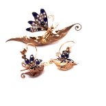 AN 18ct GOLD BROOCH AND EARRING SUITE STYLED AS A BUTTERFLIES ROWING IN LEAF FORM BOATS THE WINGS
