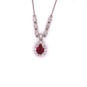 A 14ct WHITE GOLD RUBY AND DIAMOND PENDANT. THE TEARDROP RUBY CLAW SET WITH A CLUSTER OF BRILLIANT