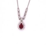A 14ct WHITE GOLD RUBY AND DIAMOND PENDANT. THE TEARDROP RUBY CLAW SET WITH A CLUSTER OF BRILLIANT
