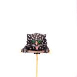 AN ANTIQUE DIAMOND AND ENAMEL STICK PIN IN THE FORM OF CAT PEERING OVER A PEARL SET BALANCE BAR.
