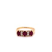 A 14ct YELLOW GOLD DIAMOND AND RUBY HALF HOOP RING. THREE OVAL CUT RUBIES ARE INTERSPERSED WITH A