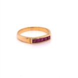 A YELLOW GOLD (UNMARKED) CHANNEL SET RUBY HALF HOOP RING. FINGER SIZE O. WEIGHT 2.7grms.