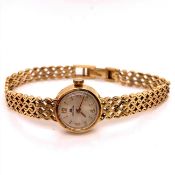 A LADIES 18ct GOLD BUCHERER BRACELET WATCH WITH A LADDER CLASP, AND A SILVER BATON NUMBER DIAL.