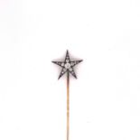 AN ANTIQUE DIAMOND STAR BURST STICK PIN. A CENTRAL OLD CUT DIAMOND RADIATED BY FIFTEEN GRADUATED OLD