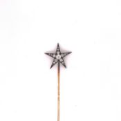 AN ANTIQUE DIAMOND STAR BURST STICK PIN. A CENTRAL OLD CUT DIAMOND RADIATED BY FIFTEEN GRADUATED OLD