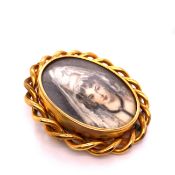 AN ANTIQUE GOLD OVAL BROOCH WITH ROPE EDGE BORDER, CENTRED WITH A ROTATING PANEL OF A PAINTED