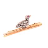 AN ANTIQUE OLD CUT DIAMOND SET DUCK BROOCH SAT UPON A PAIR OF ROWING OARS. THE PAVE SET DUCK WITH