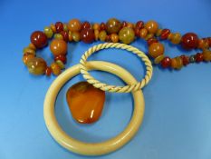 AN IVORY AND GOLD TWISTED BANGLE, A FURTHER IVORY BANGLE, AN AMBER PENDANT AND AN IRREGULAR ROW OF