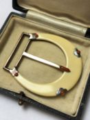A 1920'S CARTIER PARIS IVORY AND CORAL BELT BUCKLE, THE BUCKLE OF HORSESHOE DESIGN INSET WITH A