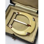 A 1920'S CARTIER PARIS IVORY AND CORAL BELT BUCKLE, THE BUCKLE OF HORSESHOE DESIGN INSET WITH A