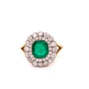AN ANTIQUE EMERALD AND DIAMOND CLUSTER RING. THE EMERALD CENTRE SURROUNDED BY A DOUBLE HALO OF OLD