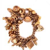 A 9ct GOLD CHARM BRACELET WITH TWENTY-THREE ATTACHED CHARMS TO INCLUDE A TYPEWRITER, FROG,