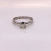 14ct WHITE GOLD FOUR CLAW SET DIAMOND SOLITAIRE RING WITH DIAMOND SET SHOULDERS. FINGER SIZE M 1/