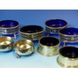 A SET OF FOUR 19th C. PIERCED HALLMARKED SILVER TABLE SALTS WITH BLUE GLASS LINERS, A FURTHER PAIR