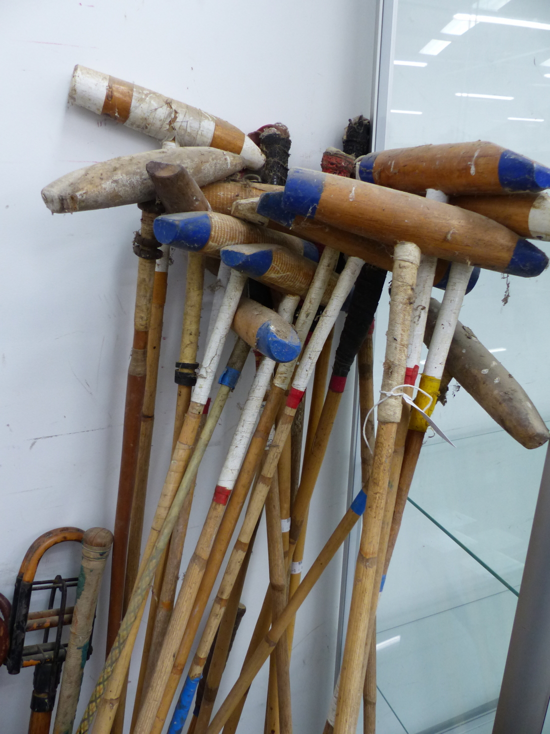 A LARGE COLLECTION OF POLO MALLETS AND HELMETS, TOGETHER WITH TWO SHOOTING STICKS, ETC (QTY).