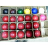 A BOXED SET OF TWENTY ONE STAINED IVORY SNOOKER BALLS TOGETHER WITH A WHITE CERAMIC BALL.