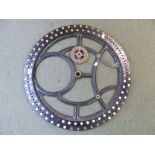 A GEAR WHEEL FROM A CLOCKING IN CLOCK, THE RIM WITH PAPER NUMBER ROUNDELS, THE WHEEL. Dia. 67cms.