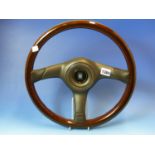 A NARDI STEERING WHEEL, THE LAMINATED WOOD RIM JOINED BY THREE BLACK BARS CENTRING ON THE HORN
