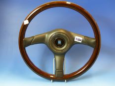 A NARDI STEERING WHEEL, THE LAMINATED WOOD RIM JOINED BY THREE BLACK BARS CENTRING ON THE HORN