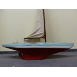 A LARGE POND YACHT IN BLUE, WHITE AND RED WITH PLANK DECK AND BRASS FITTINGS.